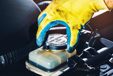 the-mechanic-hand-is-open-or-close-the-cap-of-the-power-steering-fluid-to-check-the-hydraulic-fluid-level.jpg The mechanic hand is open or close the cap of the power steering fluid to check the hydraulic fluid level