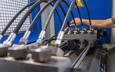 A man's hand turns on a set with for testing high pressure hydraulic hoses
