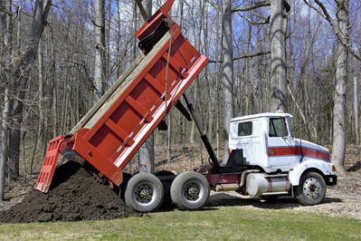 Truck unloads sand on the construction site