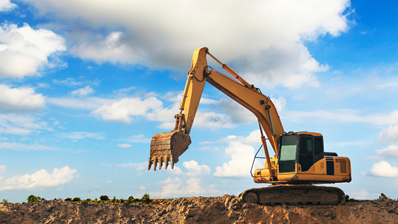 Excavator digging and loading dirt at the construction site