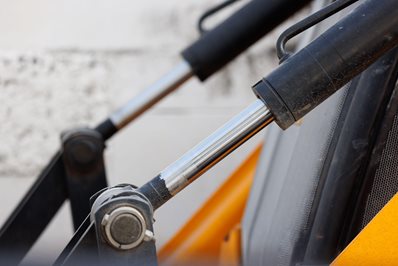 Close-up of hydraulic cylinder rods on heavy machinery equipment.