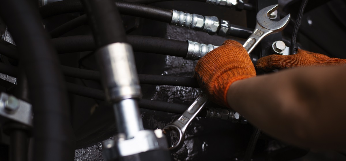 Low key photo of hydraulic pipes maintenance on heavy industry machine Low key photo of hydraulic pipes maintenance on heavy industry machine