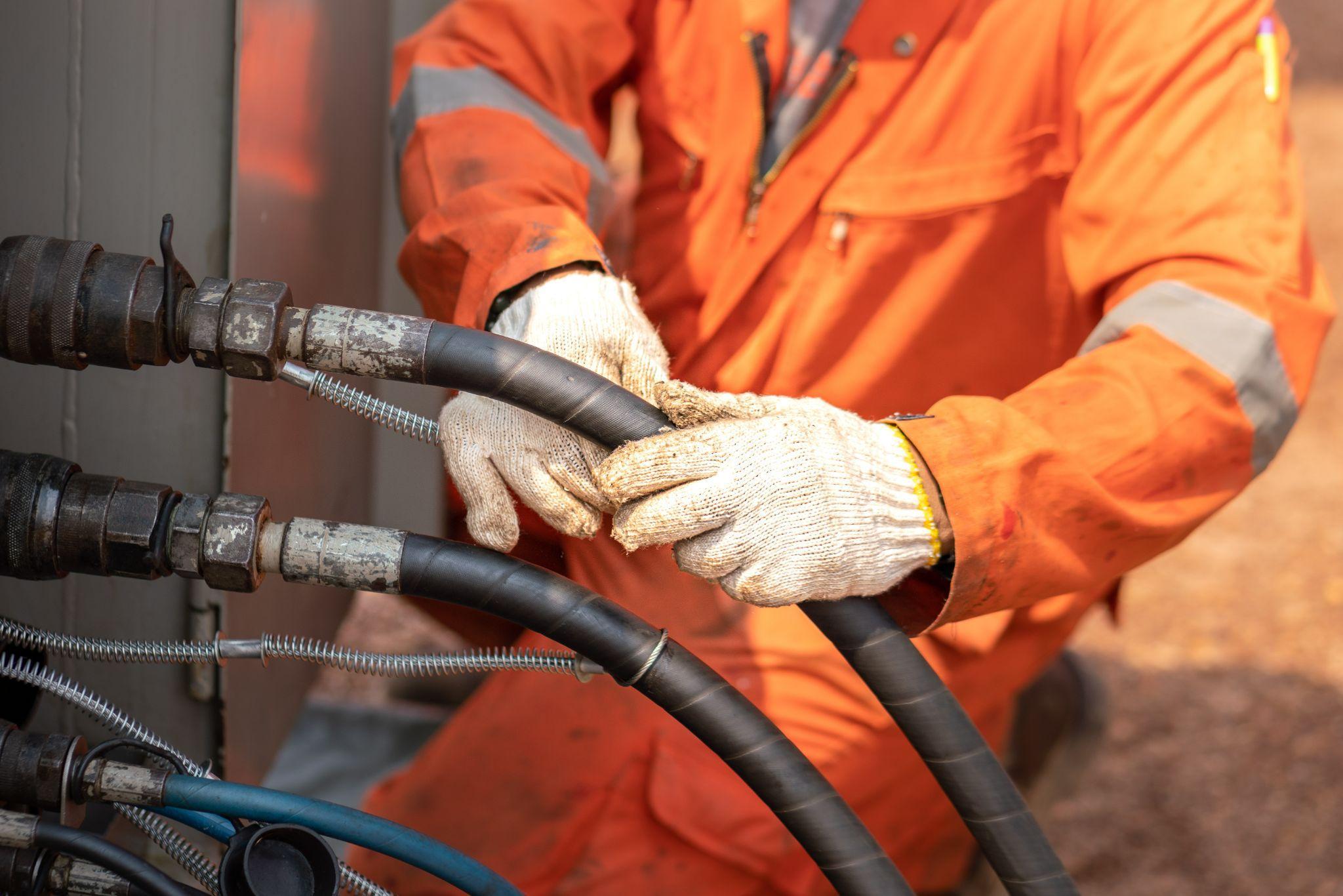 worker hand is connecting and checking to high-pressure hydraulic hose line of power pack engine. worker hand is connecting and checking to high-pressure hydraulic hose line of power pack engine.