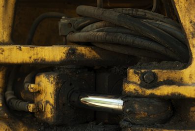 dirty oily fragment of the hydraulic drive of the steering gear of a quarry loader